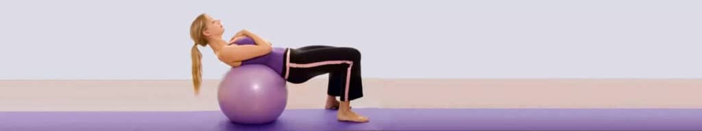 Women on gym-ball getting treated for spondylolisthesis