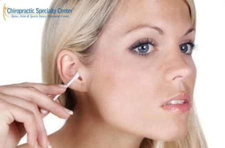 lady using cotton swab to clear obstruction in ear