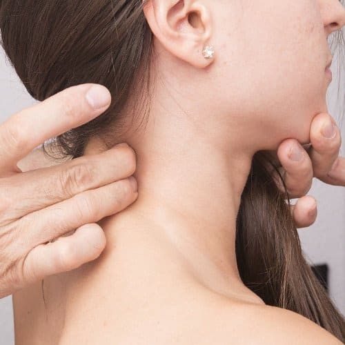 Chiropractor assessing upper neck of female