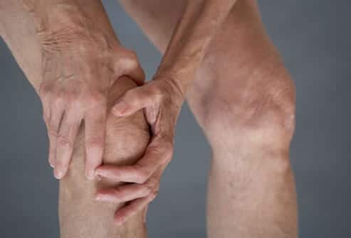 man holding an arthritic knee in pain