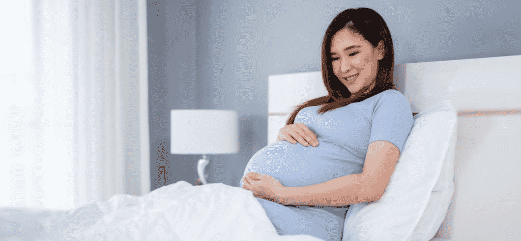 Pregnant woman lying on bed with pregnancy pain