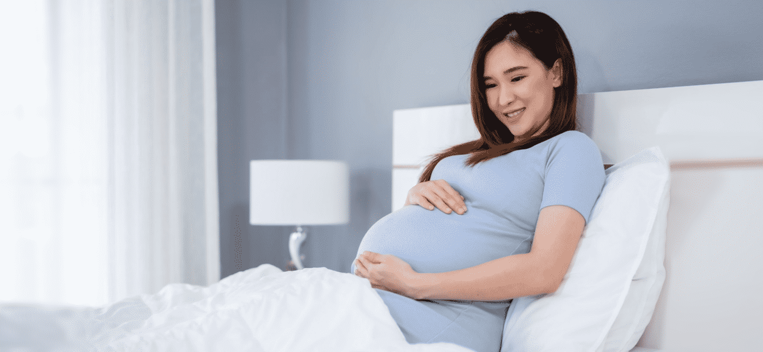 pregnant woman resting on bed pregnancy chiropractic care Malaysia