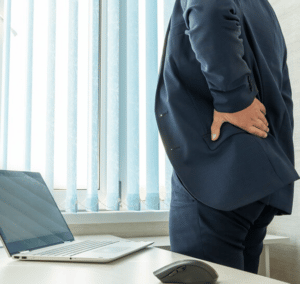 A man holding his lower back and seems in pain and he will need to visit a professional chiropractor to help care for his lower back joints and mobility.