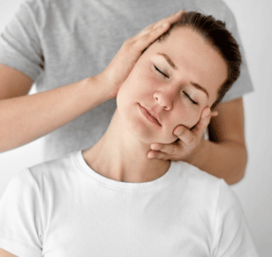 A professional chiropractor who is giving a female client a neck adjustment to help her and give her better mobility and care for her neck joints and mobility.