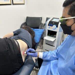 Physiotherapists treating female with back pain in Kuala Lumpur with High Intensity Laser Therapy (HILT)