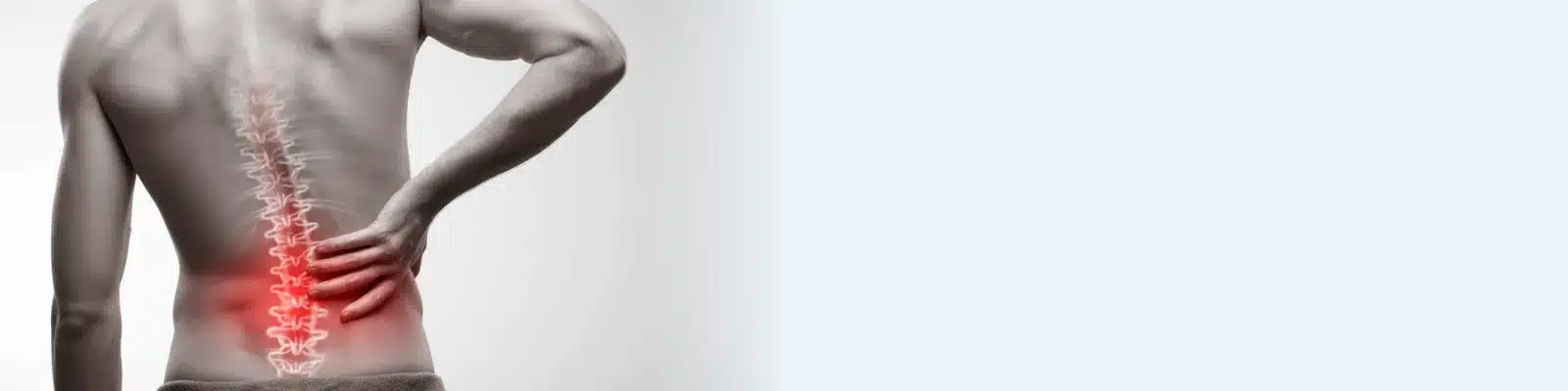 A man's bare back from behind, his hand on his lower back where a red glow marks the lumbar spine, the area a herniated disc often affects